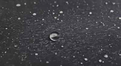 Water Droplets On A Dark Textured Surface
