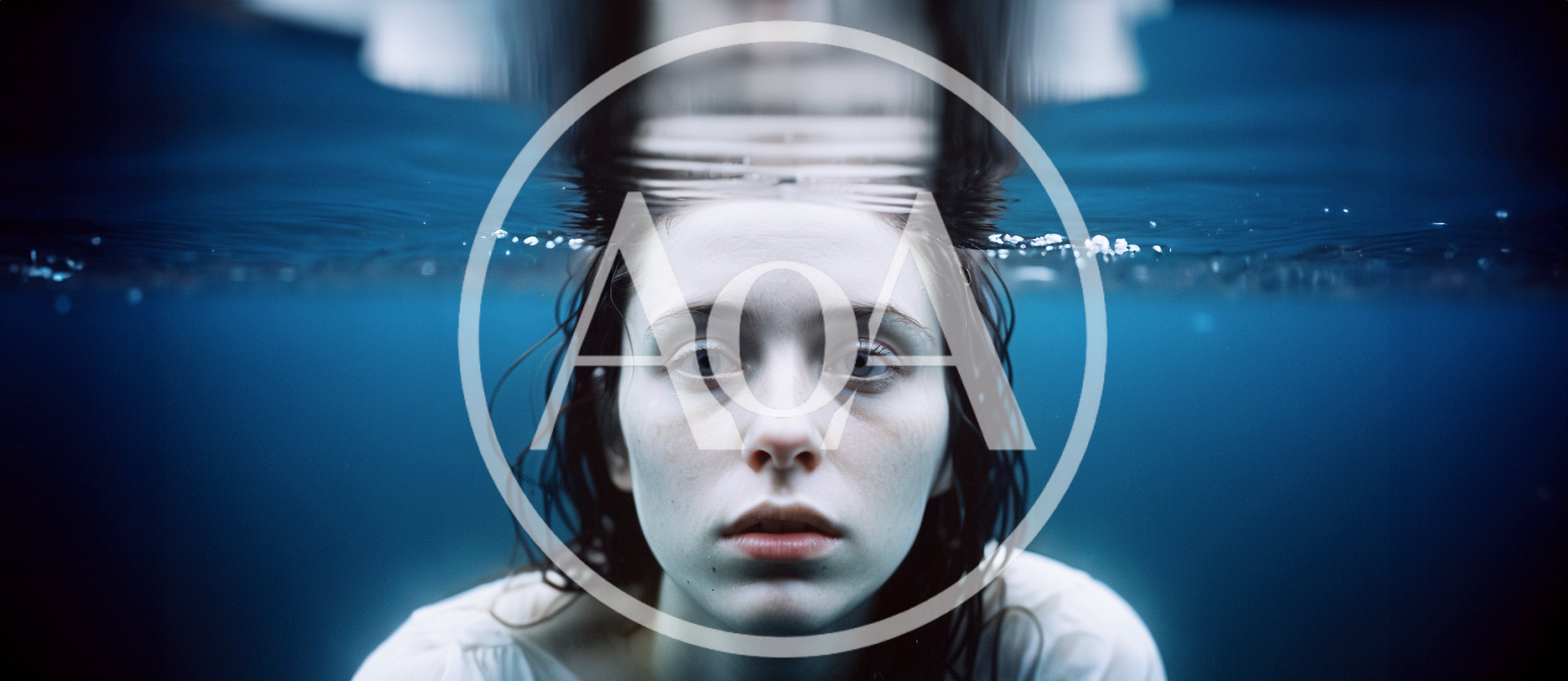 Young Woman Submerged Underwater Looking At Camera