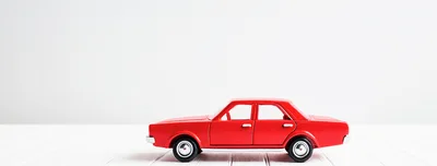 Red Toy Car On White Wooden Surface