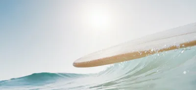 Wooden Surfboard Gliding Over A Breaking Ocean Wave