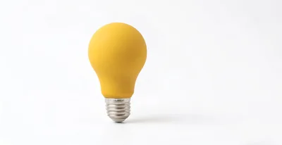 Yellow Light Bulb Standing On White Background