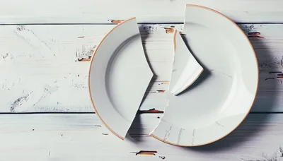 Broken White Ceramic Plate On Distressed Wooden Table