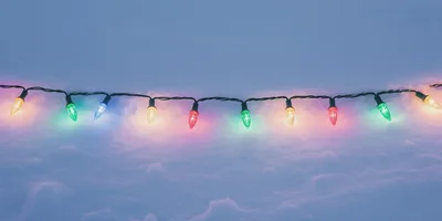 String Of Colorful Christmas Lights On Fresh Snow