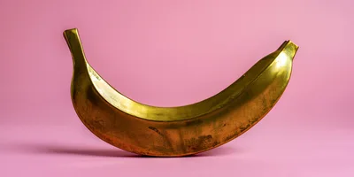 Golden Banana Sculpture On Pink Background