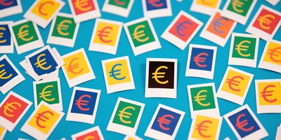 Scattered Euro Symbol Polaroid Prints on Blue Background