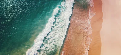 Aerial View Of Ocean Waves Crashing On Sandy Beach