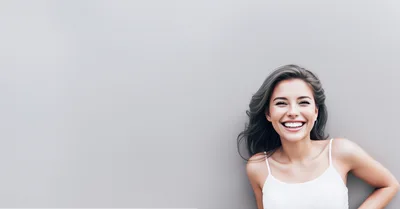 Smiling Young Woman Against A Plain Gray Background