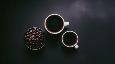 Top View Of Coffee Beans And Two Cups