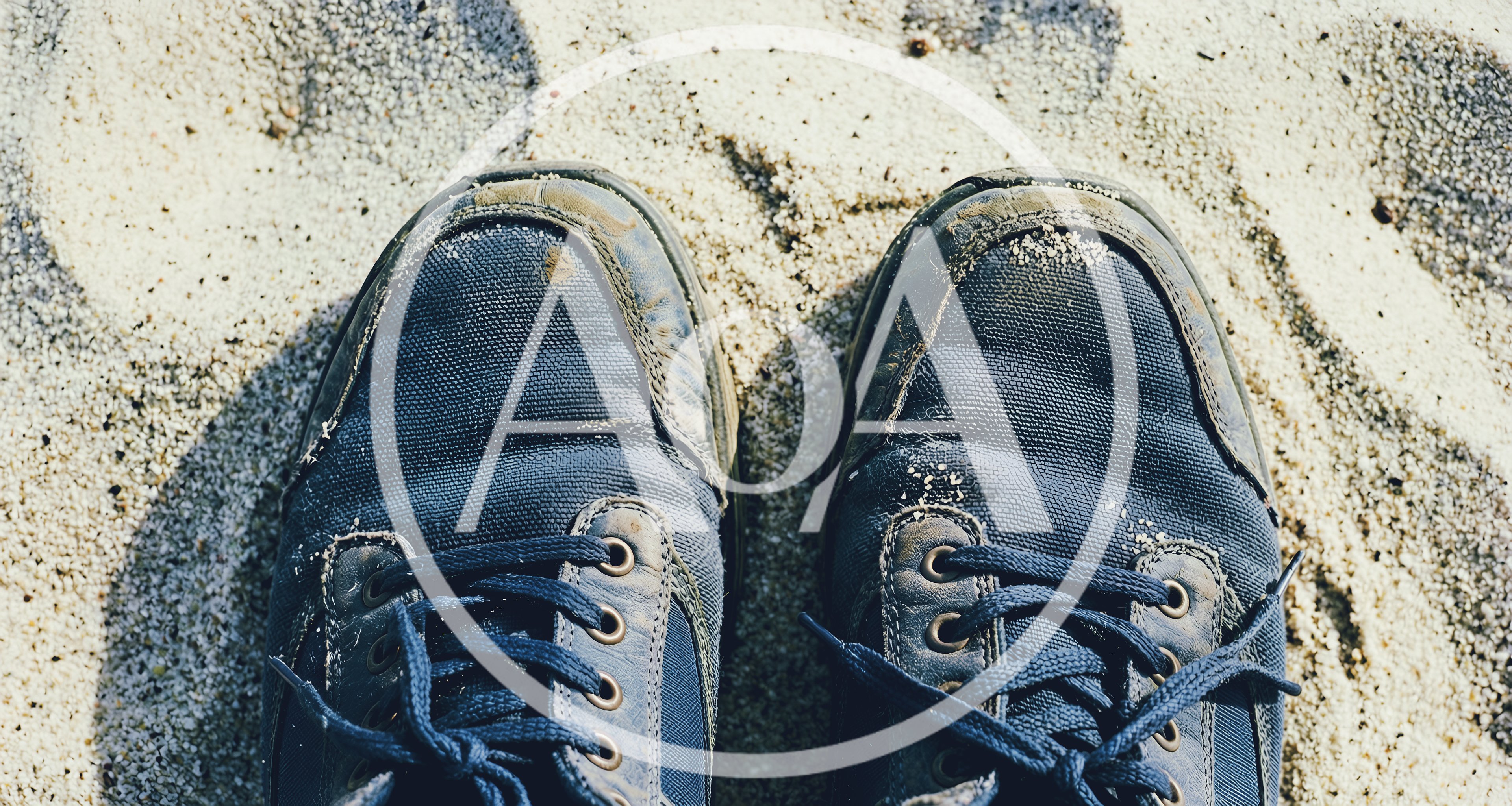 Pair Of Blue Sneakers Standing On Sandy Beach