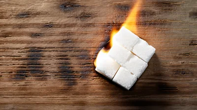 Sugar Cubes Burning on a Rustic Wooden Surface