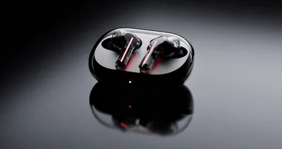 Wireless Earbuds In Charging Case On Reflective Surface