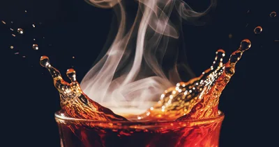 Hot Coffee Splashing Out Of A Glass Cup