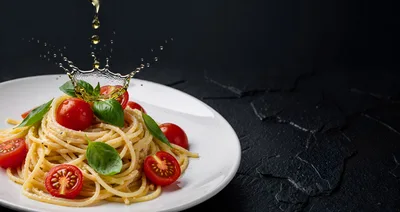 Olive Oil Pouring Over Spaghetti With Tomatoes
