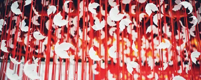White Paper Leaves Hanging From Red Strings