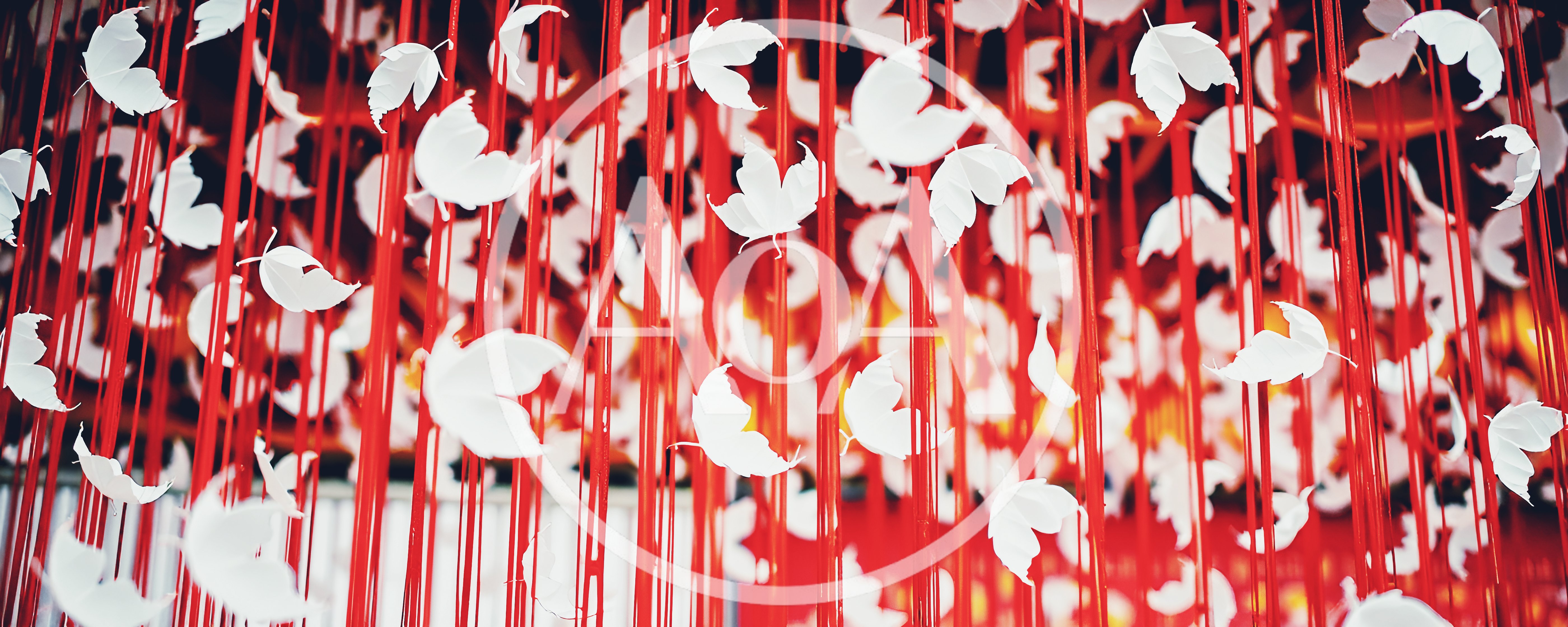 White Paper Leaves Hanging From Red Strings