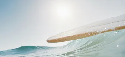 Wooden Surfboard Gliding Over A Breaking Ocean Wave