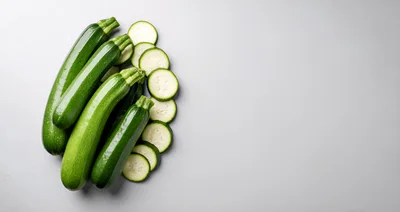 Fresh Green Zucchini Squash and Slices on Grey Background