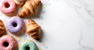 Assorted Glazed Donuts and Croissants on Marble Surface