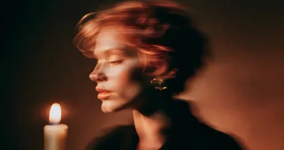 Woman With Motion Blur Effect Beside A Lit Candle