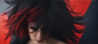 Woman With Red And Black Hair Flipping Her Head