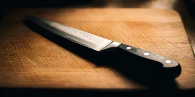 Chef Knife Resting On A Wooden Cutting Board