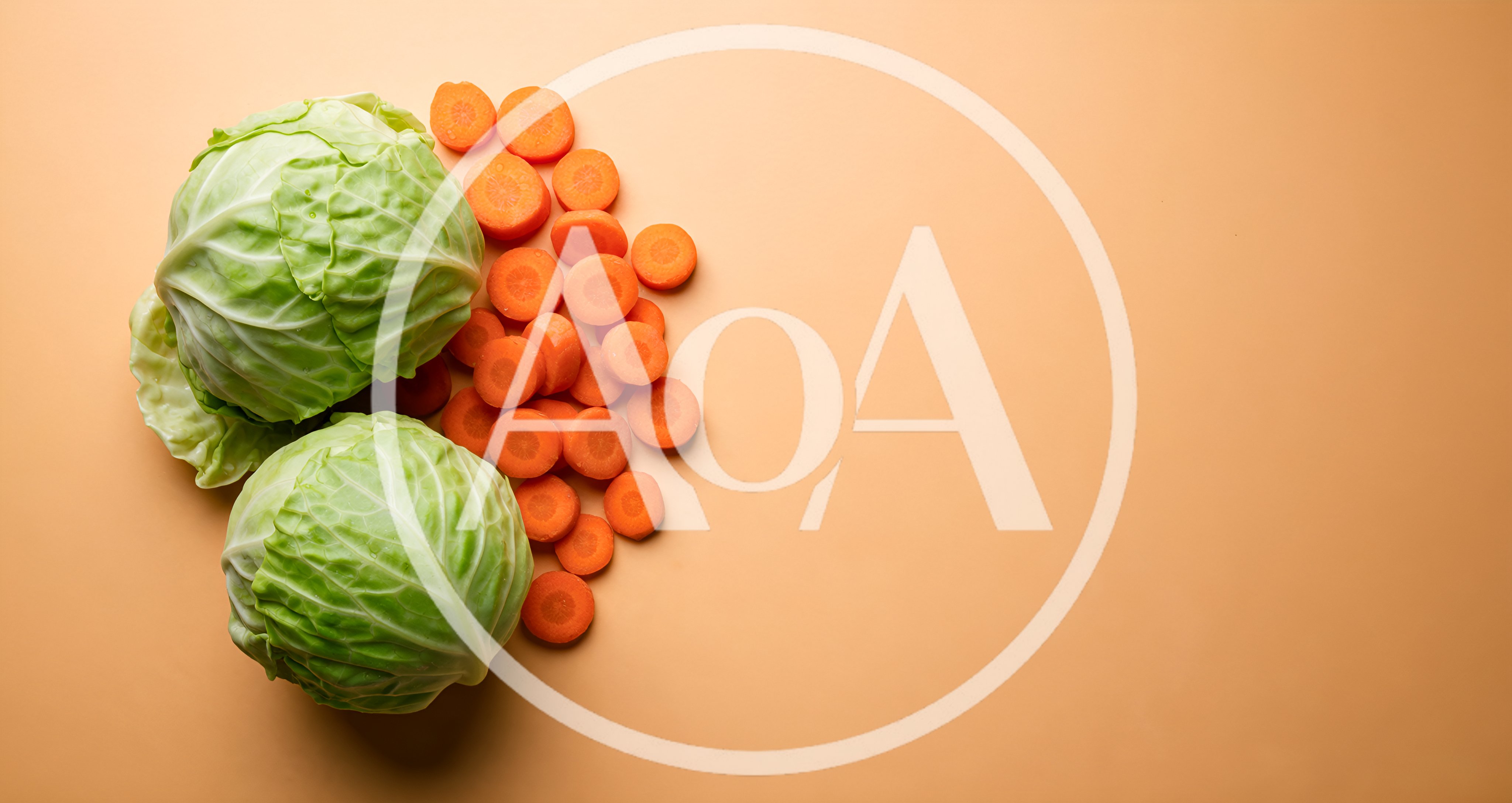 Fresh Cabbage Heads and Sliced Carrots on Orange Background
