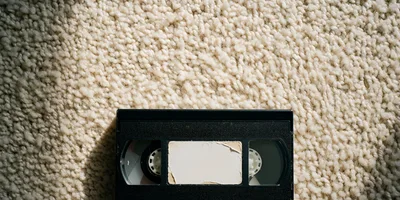 Vintage VHS Videocassette Tape Resting On Textured Carpet