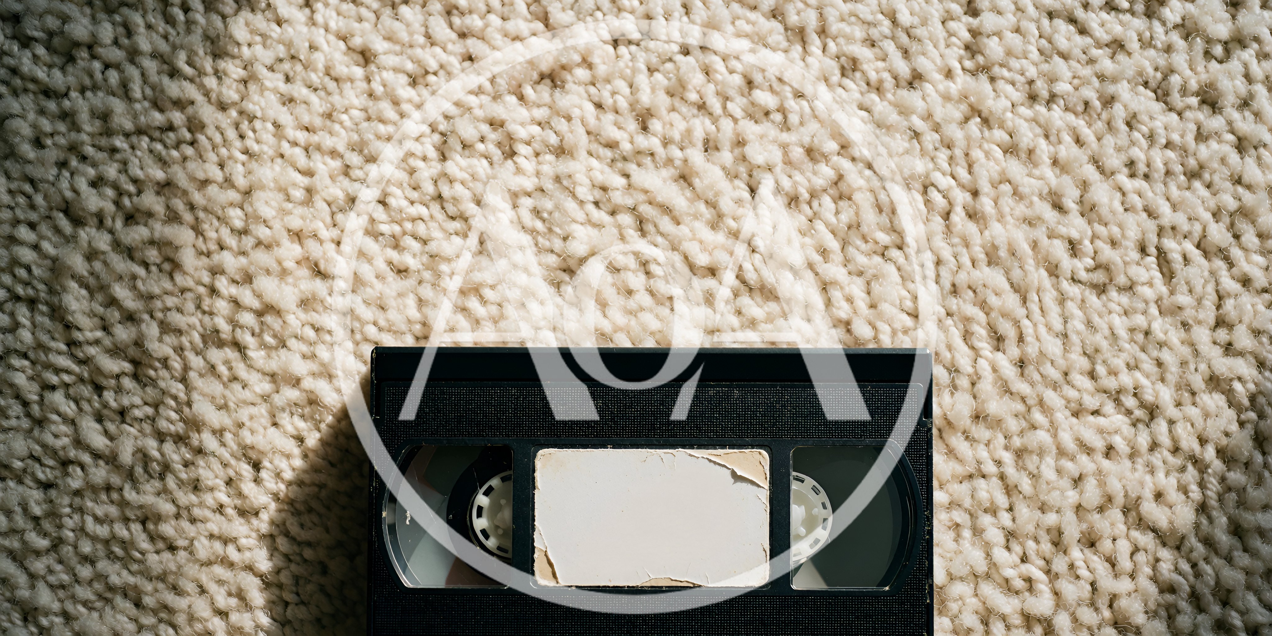 Vintage VHS Videocassette Tape Resting On Textured Carpet