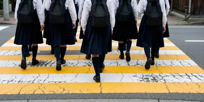 Japanese Schoolgirls Walking Across A Pedestrian Crosswalk