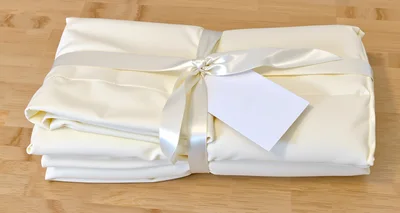 Folded Cream Bed Sheets Tied With Satin Ribbon