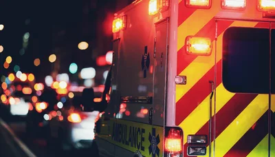 Ambulance Driving Through City Traffic At Night
