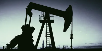 Oil Pump Jack Silhouette Against A Twilight Sky