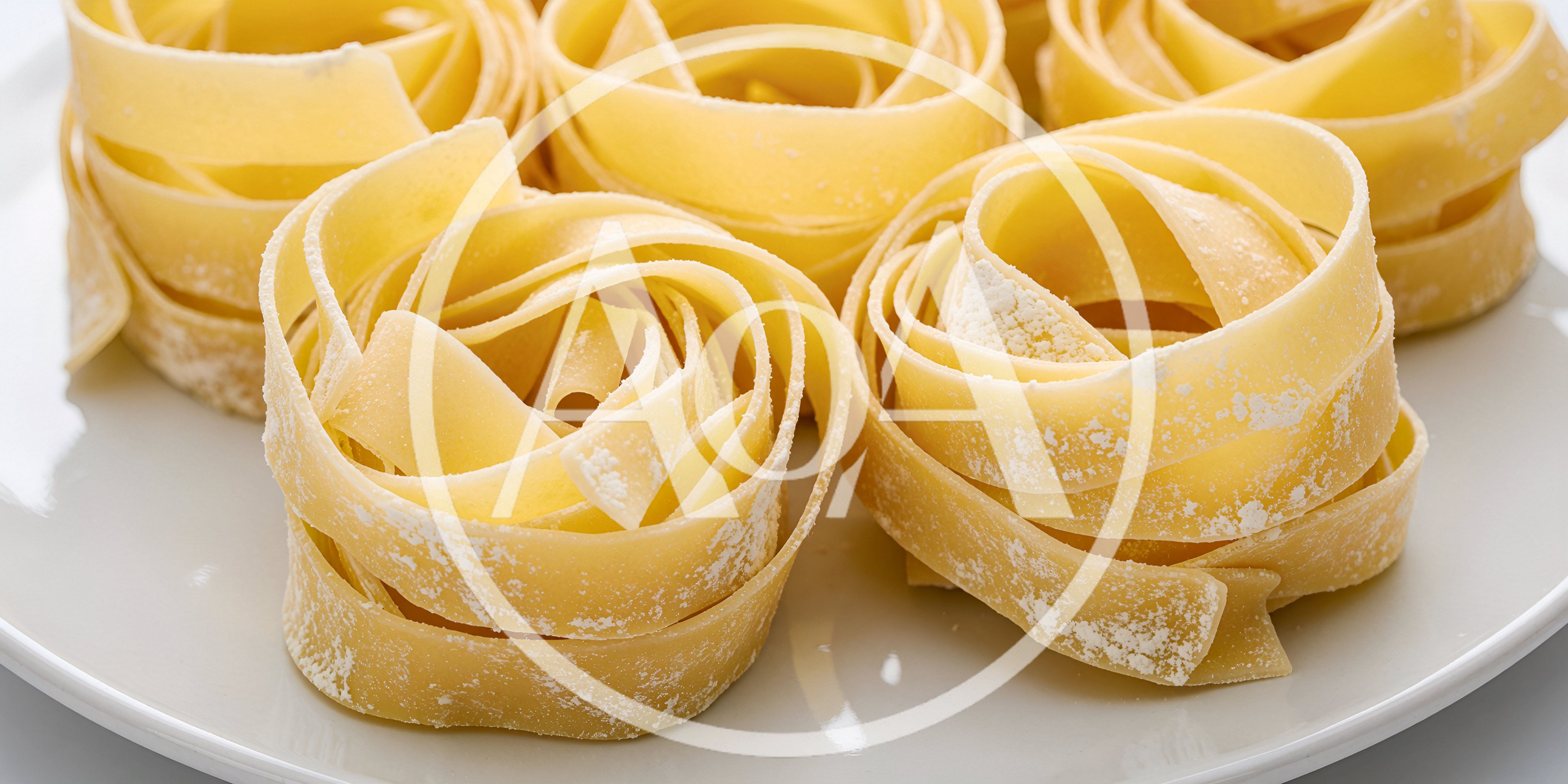 Raw Tagliatelle Pasta Nests on a White Plate