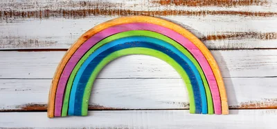 Wooden Rainbow Toy On White Distressed Wood Background