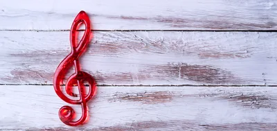 Red Treble Clef Symbol on White Wooden Background