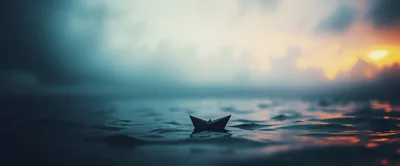 Small Paper Boat Floating On Calm Dark Water
