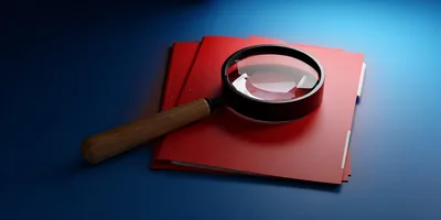 Magnifying Glass Resting On Red File Folders