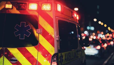 Ambulance Driving Through City Traffic At Night