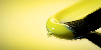 Paintbrush Spreading Thick Yellow Paint On Surface