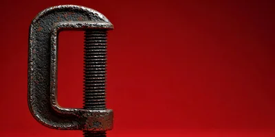 Close Up Of A Metal C-Clamp On Red Background
