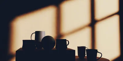 Silhouetted Mugs And Sphere On A Table