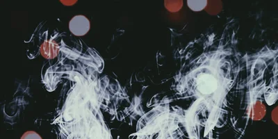 Abstract White Smoke Swirls Against Dark Background