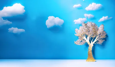 Golden Tree Sculpture Against Blue Sky With Clouds
