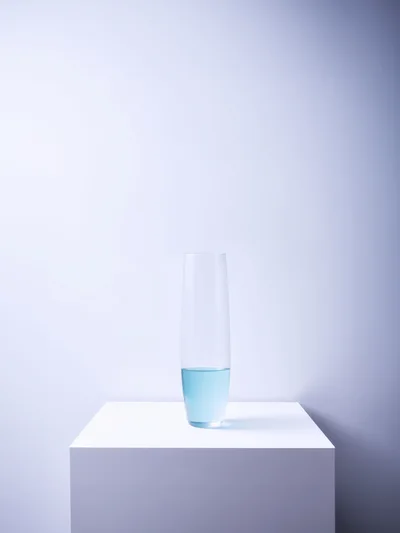 Clear Glass Vase With Blue Liquid On White Pedestal