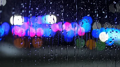 Raindrops Running Down A Window At Night
