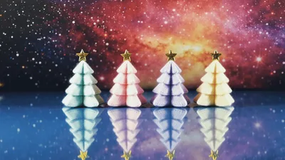 Four Pastel Christmas Trees Against A Galaxy Background