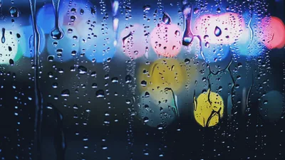 Raindrops On Windowpane With Blurred City Lights