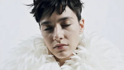Androgynous Model With Short Hair Posing In White Feathers