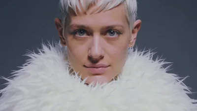 Short Haired Woman Wearing White Fur Collar Looking Forward
