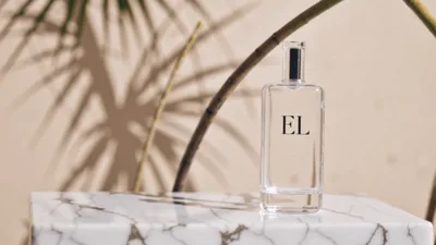 Clear Perfume Bottle With EL Label On Marble Surface